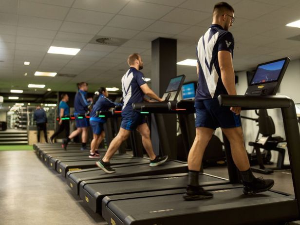 Group of men using treadmill machines