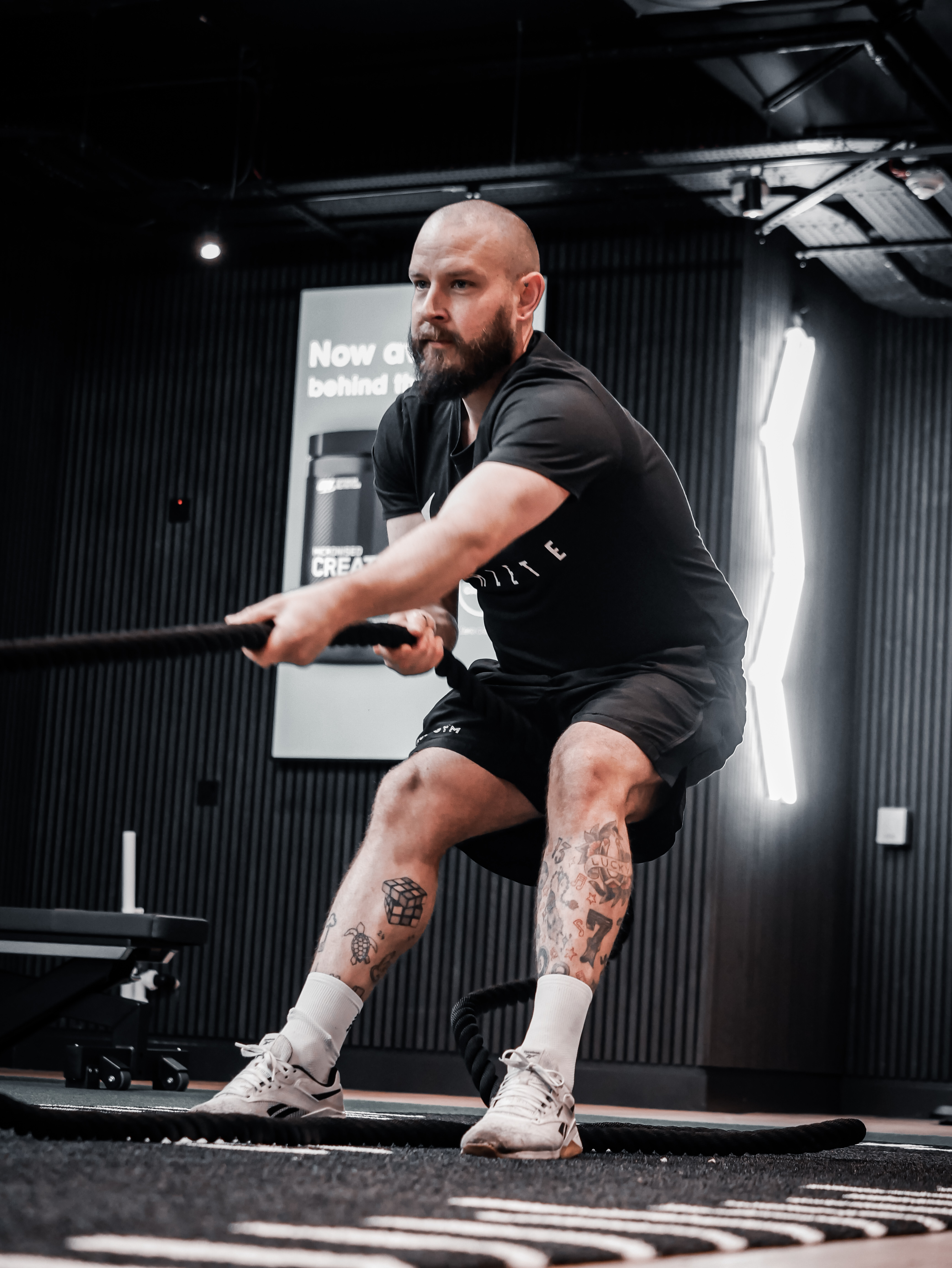 A personal trainer instructs a woman during a workout session in a gym setting.