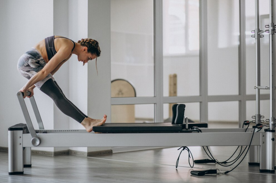 Woman using a reformer Pilates machine