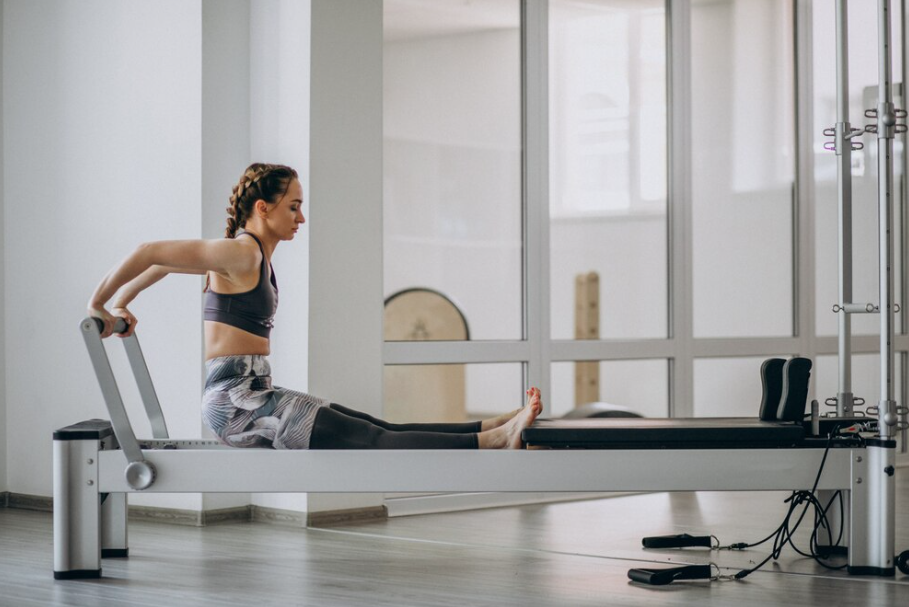 Woman using a reformer Pilates machine