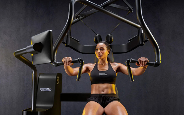 Woman using technogym biostrength machine
